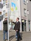 Oberbürgermeister Andreas Henke rechts und Thomas Wald, Leiter der Abteilung Stadtgrün, beim Aufziehen der Fahne mit dem offiziellen Logo für ENTENTE FLORALE vor dem Halberstädter Rathaus Foto J. Scholz