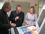 Firmenchef Andreas Koch li.  und Susanne JahnsmüllerKoch erklären Oberbürgermeister Andreas Henke das Prinzip des ProzessStandardOffsetdrucks – hier am Beispiel einer 5FarbOffsetdruckmaschine     