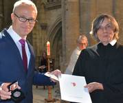 Oberbürgermeister Andreas Henke (Die Linke) überreicht Pfarrerin Hannah Becker die Verdienstmedaille der Stadt.