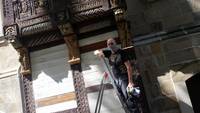 Museumsmitarbeiter André Pohl bei der Behandlung der Holzfiguren nach Wiederanbringung