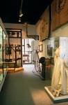 Blick in den Ausstellungsabschnitt Geschichte der Stadt Halberstadt zwischen 1830 und 1870 mit dem Brautkleid aus Ströbeck, um 1870