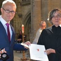 Oberbürgermeister Andreas Henke (Die Linke) überreicht Pfarrerin Hannah Becker die Verdienstmedaille der Stadt.