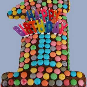 Kuchen in Form der Ziffer 1, Kerzen bilden den Schriftzug "Happy Birthday"