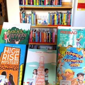 Sommerliche Kinderbücher vor dem Lesesommer-Regal