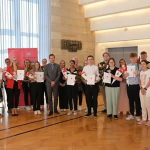 Am 1. August begann in der Stadt Halberstadt das neue Ausbildungsjahr. Ausbildungsleiterin Anke Dietrich und Oberbürgermeister Daniel Szarata konnten bei der Eröffnungsfeier im Rathaus sowohl die bisherigen als auch die neuen Auszubildenden, die Ausbilder und Mitglieder der Personalvertretung begrüßen.  Zu Beginn erhielten alle Auszubildenden, die ihre dreijährige Ausbildung erfolgreich beendet haben, ihren Arbeitsvertrag mit der Stadt.   Zu ihnen gehören Hannes Zimpel als Verwaltungsfachangestellter, René Zehnpfund als Fachangestellter für Medien- und Informationsdienste und Conrad Schrader als Fachinformatiker für Systemintegration sowie Konrad Krause als Tierpfleger im Tiergarten.  Die neu ausgebildeten Fachkräfte zeigten während ihrer Ausbildung großes Engagement für die Stadt. So beteiligten sie sich an der Realisierung zahlreicher Projekte aus ihren Fachbereichen.   Beim Azubi-Projekt mit Wolfsburg, bei der Vorbereitung und Durchführung der Kommunalwahlen, dem Bürgerbrunch, den Special Olympics, dem Tiergartenfest und bei vielen anderen Aktivitäten konnte sich die Stadt auf „ihre“ Azubis verlassen.  Neu im Auszubildendenteam der Stadt sind Vanessa Katharina Reese und Erika Selina Koch Septimo, die eine Ausbildung als Verwaltungsfachangestellte in der Fachrichtung Kommunalverwaltung beginnen.   Emily Germer und Carl Vitus Mock streben eine Ausbildung als Fachangestellte für Medien- und Informationsdienste in der Fachrichtung Bibliothek an. Johanna Karin Seeliger wird in der Tourist Info zur Kauffrau für Tourismus und Freizeit ausgebildet. Chris Arne Baumgardt-Garten möchte im Tiergarten den Beruf des Tierpflegers in der Fachrichtung Zoo erlernen.   Nach der Übergabe der Arbeits- und Ausbildungsverträge gab es in einer Gesprächsrunde noch einige Tipps für die Berufsanfänger. Sie wurden ermutigt, alle Möglichkeiten zu nutzen, die ihnen während ihrer Ausbildung geboten werden. Sie sollen fleißig, interessiert und offen für Neues sein.   Oberbürgermeister Daniel Szarata gratulierte zur abgeschlossenen Ausbildung und begrüßte die neuen Auszubildenden. Er sagte:  „Es erfüllt mich mit Freude, dass der ausgezeichnete Ruf der Stadt Halberstadt als Ausbildungsbetrieb viele junge Menschen dazu bewegt, sich bei uns zu bewerben. Die Übernahme aller Auszubildenden, stellt eine wesentliche Motivation für unsere neuen Azubis dar. Mein herzlicher Dank gilt allen Ausbildern, die ihrer großen Verantwortung gerecht werden.“   Interessenten an einem der zahlreichen Ausbildungsberufe der Stadt können sich auf der bevorstehenden Berufs- und Studienmesse [BeSt]4 am 7. September auf dem Gelände des Burchardiklosters in Halberstadt ausgiebig informieren.   Foto: Stadt Halberstadt/ Holger Wegener Text: Festveranstaltung für die Auszubildenden und Ausgebildeten im großen Ratssitzungsaal ©Stadt Halberstadt