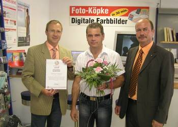 Geschäftsinhaber Peter Köpke freute sich über die Glückwünsche des  Oberbürgermeisters Andreas Henke links und des Unternehmerbürochefs Thomas Rimpler rechts.  Foto: U. Huch
