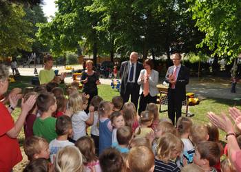 Bundestagsabgeordnete Heike Brehmer, Oberbürgermeister Andreas Henke und Amtsleiter Andreas Karger sind vom kleinen Ständchen der Kinder sichtlich beeindruckt