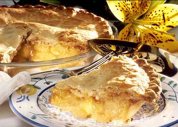 Ein Stück Apfelkuchen auf einem Teller; im Hintergrund die Form mit dem restlichen Kuchen ©Public domain