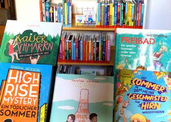 Sommerliche Kinderbücher vor dem Lesesommer-Regal ©Stadtbibliothek 