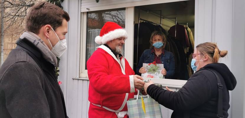 (v. l. n. r.): Oberbürgermeister Daniel Szarata, der Weihnachtsmann und Maria Oppermann von der Wärmestube freuen sich, dass die ersten Geschenke des Wunschweihnachtsbaumes an die Familien übergeben werden konnten © Stadtmarketing/Öffentlichkeitsarbeit