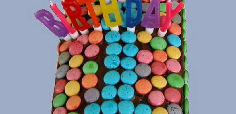 Kuchen in Form der Ziffer 1, Kerzen bilden den Schriftzug "Happy Birthday"