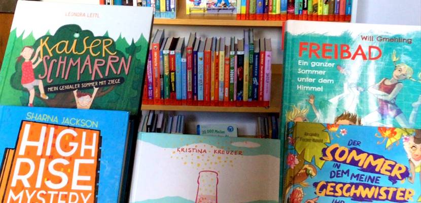 Sommerliche Kinderbücher vor dem Lesesommer-Regal